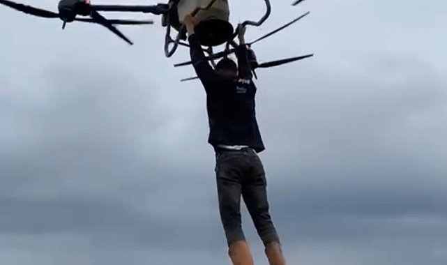 Çiftçi, drona tutunarak tarlanın diğer tarafına geçti