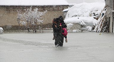 Evinin önünde biriken su nedeniyle çocuklarını sırtında taşıyor