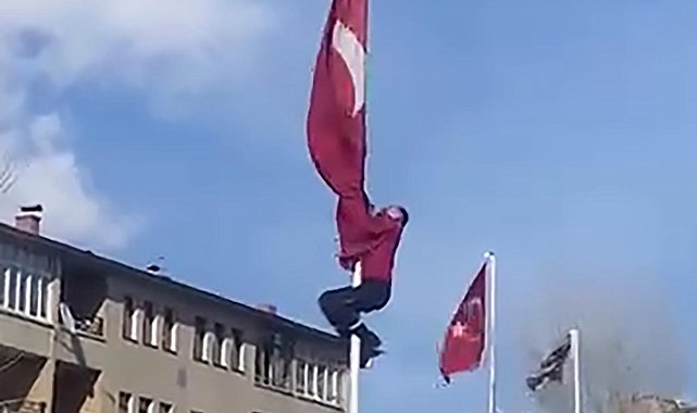 Rüzgârda dolanan bayrağı düzeltmek için 15 metrelik direğe tırmandı; o anlar görüntülendi