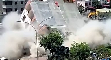 Apartmanın yıkımı sırasında, kaldırımdaki kadın enkaz altında kalmaktan son anda kurtuldu