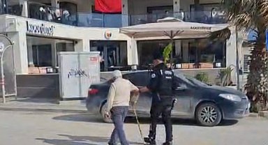 Hatay'da polisin, yolun karşısına geçmekte zorlanan kişiye yardım ettiği anlar kamerada