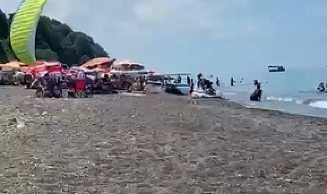 Sahilde motorlu yamaç paraşütüyle havalanırken tatilcilerin arasına daldı