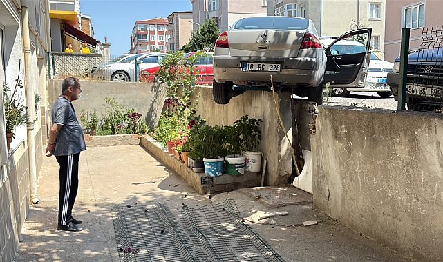 El freni çekilmeyen otomobil, hareket edip istinat duvarında asılı kaldı