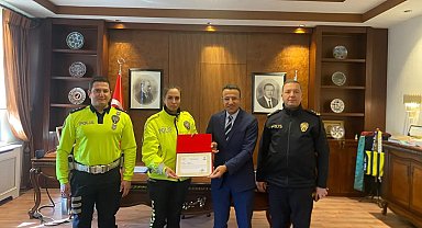 Yaralı ıslanmasın diye başında şemsiyeyle bekleyen kadın polise başarı belgesi